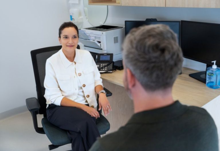 Healthcare professional speaking with a patient during a private consultation.